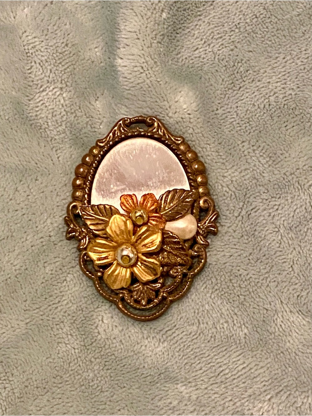 Vintage mirror and floral brooch